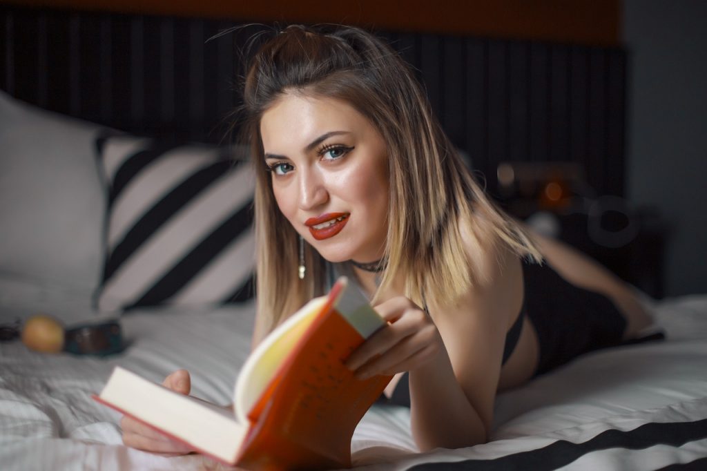 אישה עם ספר במיטה